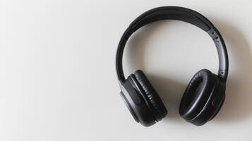 Sleek black wireless headphones on white table, perfect for music lovers and tech enthusiasts. photo
