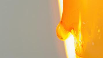 Golden honey dripping from a dipper, illuminated by sunlight in a close-up shot photo