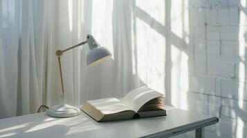 Sunlit open book with desk lamp on white table creating cozy ambiance photo