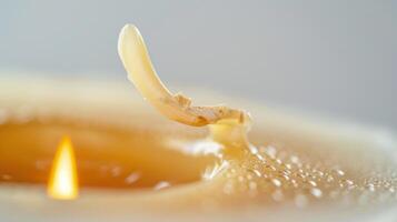 Close-up of a candle melting, wax dripping from the wick, flame flickering warmly photo