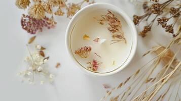 Soy candle with aromatic scent and dried flower decor sets a cozy and relaxing ambiance photo