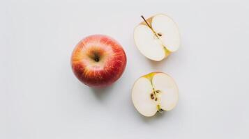 Direct top view of one whole red apple and two halves on a white background photo