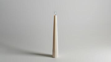 Solitary white candle illuminates a serene white backdrop, evoking feelings of calm and serenity photo