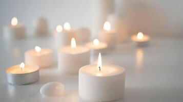 Numerous little candles emit a cozy, romantic glow against a white backdrop photo
