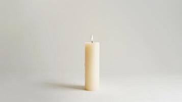 Solitary white pillar candle flickers on a serene backdrop, evoking feelings of calm and serenity photo