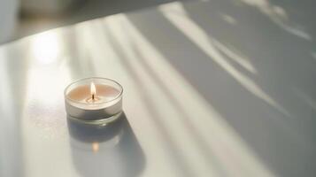 Scented candle casting a calming ambiance on a white table with window shadows photo