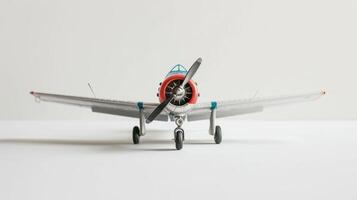 Toy airplane in blue and red on a white surface with a white background photo