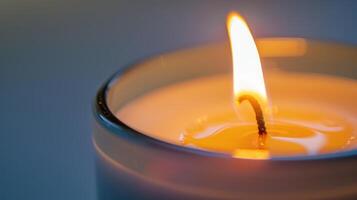 The soft yellow flame of a single white candle creates a warm and inviting glow photo