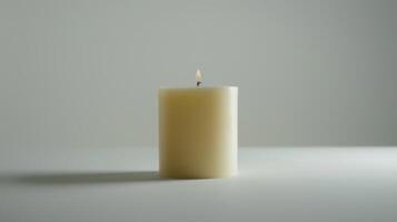 Solitary white candle illuminates a white surface with its inviting and cozy glow photo