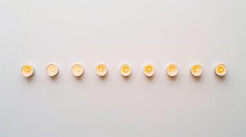 Ten glowing tea light candles casting a tranquil and serene ambiance against a white backdrop photo