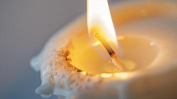 White candle burns with melted wax and a short wick, casting a cozy and welcoming light photo