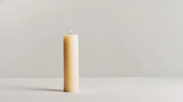 Solitary white candle illuminates a pristine white surface, creating a serene backdrop photo