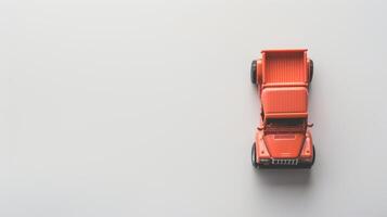 Simple orange toy pickup truck on white background with minimalist style and empty space to the left photo