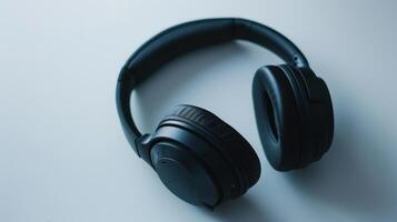 Pair of modern wireless headphones is lying on a white surface. photo