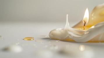 White candle is melting, its wax dripping down the side creating abstract shapes photo