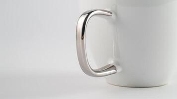 Shiny metallic handle on a white mug against a white background photo