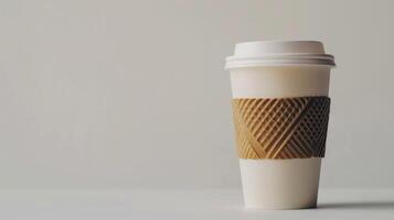 White paper coffee cup with cardboard sleeve standing on white surface with copy space photo