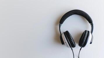 Sleek pair of headphones rests on a minimalist white table, perfect for enjoying music photo