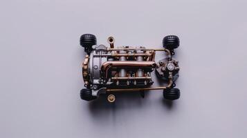 Miniature model engine sits on a white surface, its intricate gears and pipes exposed. photo