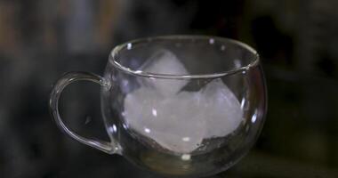 Throw ice cubes in empty glass. Ice Cubes falling down in empty transparent glass. Make a fresh drink. Footage b roll scene 4k. Slow motion. video