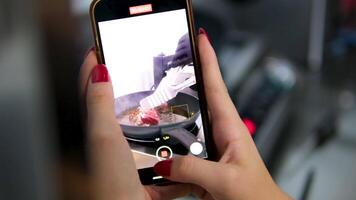 Shoot a block on a mobile phone. Fresh beef meat for cooking, cut with knife. Step by step process of cooking steak. Fresh juicy meat. Cut to measure temperature of product video