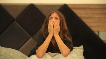 A beautiful young girl is worried, indifferent, has a lot of thoughts in her head and cannot sleep, sitting on the bed video