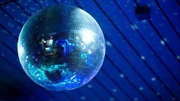 Mirrored retro disco ball spins with reflection of glare from spotlight video