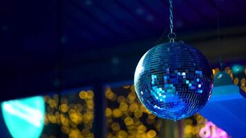 A retro mirror disco ball covered in webbing spins in a closed club video