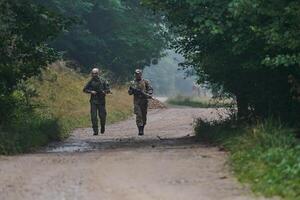 A disciplined and specialized military unit, donned in camouflage, strategically patrolling and maintaining control in a high-stakes environment, showcasing their precision, unity, and readiness for photo