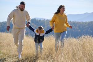 A modern family, along with their son, revels in the joy of a muddy day in nature, running and playing together, encapsulating the beauty of a healthy and active lifestyle photo
