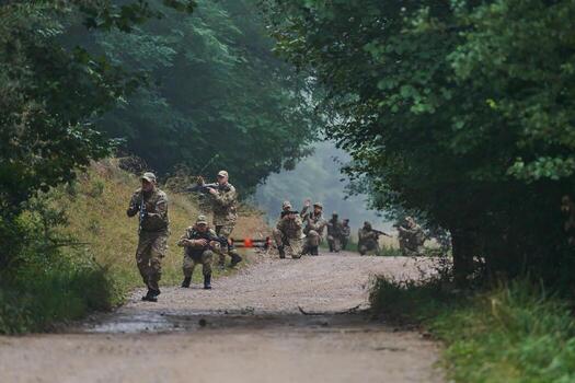Elite military unit parading and securing the forest, utilizing drones for terrain scanning and reconnaissance, showcasing their advanced skills and specialized training in high risk operations photo