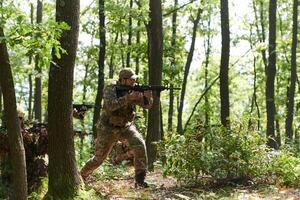 A specialized military antiterrorist unit conducts a covert operation in dense, hazardous woodland, demonstrating precision, discipline, and strategic readiness photo
