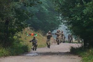 Elite military unit parading and securing the forest, utilizing drones for terrain scanning and reconnaissance, showcasing their advanced skills and specialized training in high risk operations photo