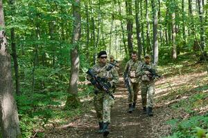 A specialized military antiterrorist unit conducts a covert operation in dense, hazardous woodland, demonstrating precision, discipline, and strategic readiness photo