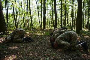 A dedicated group of soldiers engages in Islamic prayer amidst the challenging and perilous conditions of a military operation in dense forested areas photo