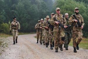 An elite military unit, led by a major, confidently parades through dense forest, showcasing precision, discipline, and readiness for high-risk operations photo