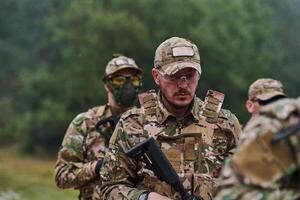 An elite military unit, led by a major, confidently parades through dense forest, showcasing precision, discipline, and readiness for high-risk operations photo