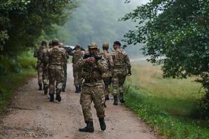 A group of elite soldiers leads captives through a military camp, showcasing a tense atmosphere of detention and security operations photo