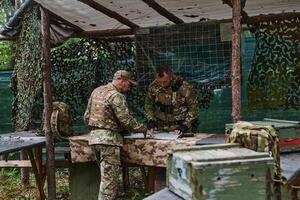 A highly trained military unit strategizes and organizes a tactical mission while studying a military map during a briefing session photo