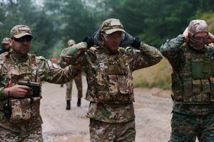 A group of elite soldiers leads captives through a military camp, showcasing a tense atmosphere of detention and security operations photo