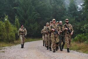 An elite military unit, led by a major, confidently parades through dense forest, showcasing precision, discipline, and readiness for high-risk operations photo