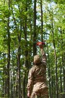 Elite military unit, equipped with state-of-the-art technology including a drone, strategically navigates and surveys dangerous wooded terrain, showcasing their precision, cooperation, and specialized photo