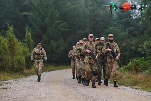 An elite military unit, led by a major, confidently parades through dense forest, showcasing precision, discipline, and readiness for high-risk operations photo