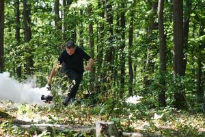 A videographer captures the intensity of a perilous military operation, documenting soldiers in action amidst the dense forest, showcasing the hazardous conditions and tactical maneuvers undertaken by photo