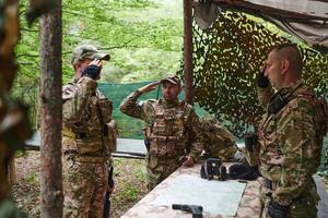 A highly trained military unit strategizes and organizes a tactical mission while studying a military map during a briefing session photo