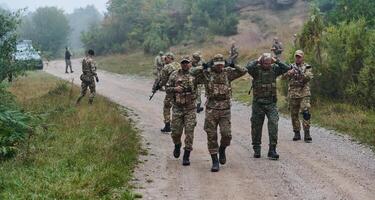 A group of elite soldiers leads captives through a military camp, showcasing a tense atmosphere of detention and security operations photo