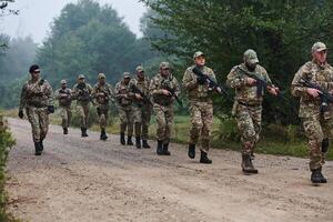 An elite military unit, led by a major, confidently parades through dense forest, showcasing precision, discipline, and readiness for high-risk operations photo