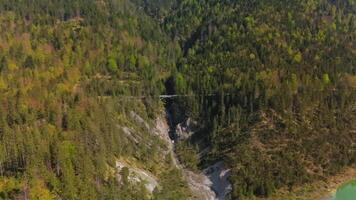 Luftaufnahme Schurpfen Wasserfall. Aerial view of crooked waterfall Schurpfen and bridge in gorge with forested mountain and canyon near Sylvensteinspeicher in Lenggries. Drone view falls and bridge. video
