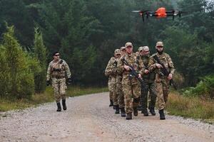 An elite military unit, led by a major, confidently parades through dense forest, showcasing precision, discipline, and readiness for high-risk operations photo