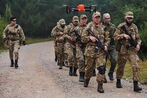 An elite military unit, led by a major, confidently parades through dense forest, showcasing precision, discipline, and readiness for high-risk operations photo
